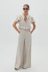 Pantalón de lino color natural, de corte palazzo y tiro alto.