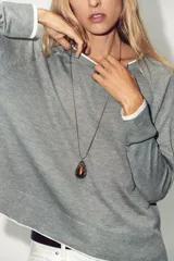 Jersey de punto verde militar con efecto doble, escote redondo y mangas largas con detalles en blanco en el cuello, puños y ruedo.