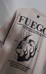 Remera de manga corta y cuello redondo con calce oversize, color beige con estampa gráfica en negro que incluye texto y un rostro femenino estilizado con llamas.