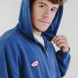 Campera con cierre frontal, capucha y bolsillos delanteros, color azul oscuro con efecto desgastado.