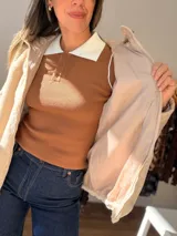 Campera con cuerpo de piel sintética tipo teddy y mangas acolchadas. Presenta cierre frontal, capucha y diseño de corte recto.
