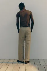 Pantalón de algodón color beige, estilo casual con corte relajado, cintura elástica con cordón de ajuste oculto y bolsillos al bies y traseros.