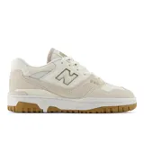 Championes urbanos New Balance modelo 550, color crema con detalles en beige y marrón. Confeccionados en cuero y gamuza, con logo "N" característico en los laterales y suela de goma.