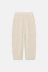 Pantalón de lino marrón oscuro, de corte barrel con pernera holgada que se estrecha hacia el tobillo, cintura elástica y bolsillos delanteros.