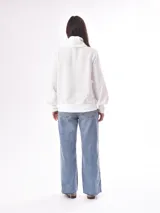 Buzo negro de punto con cuello polo con cierre de cremallera metálica, mangas largas abullonadas y bolsillos laterales.