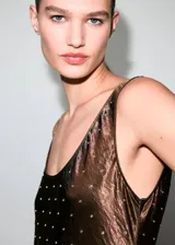 Vestido largo de fiesta con diseño recto y cuello escotado. Confeccionado en tejido satinado con efecto arrugado y adornado con pequeños cristales distribuidos por toda la prenda. Presenta tirantes anchos y un corte sin mangas.