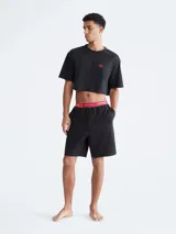 Short de dormir negro de corte relajado, largo a media pierna, con bolsillos laterales. Presenta una pretina elástica de jacquard suave en color rojo y blanco con el logo de Calvin Klein y la frase "This is Love".