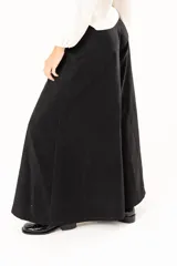 Pantalón de corte palazzo en color negro, con cintura alta, cierre frontal con botón y costuras verticales que definen su estructura amplia.