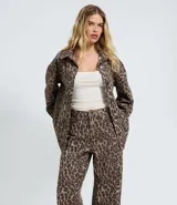 Pantalón baggy de sarga con estampado animal print, corte holgado y cintura mediana. Cuenta con bolsillos funcionales, trabillas para cinturón y cierre frontal con botón y cremallera.