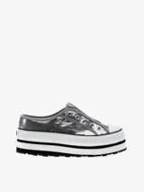 Zapatilla plateada con lentejuelas, estilo slip-on, con plataforma blanca y suela negra.
