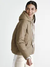 Campera puffer color visón con capucha y cierre frontal con cremallera. Presenta cordones blancos con letras negras en la capucha y en los puños.