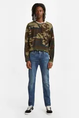 Jean de calce ajustado color azul medio, tiro medio y confección en denim rígido.