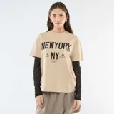 Camiseta de manga corta color beige con estampado gráfico frontal en negro, que incluye una segunda capa de mangas largas de encaje negro debajo.