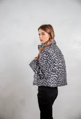 Campera puffer con estampado animal print en tonos gris y negro, cuello alto y cierre frontal.
