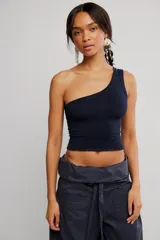 Top negro de un solo hombro, de calce ajustado y corte corto, confeccionado en punto elástico con costuras decorativas verticales.