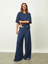 Pantalón azul oscuro de corte recto y tiro alto, con cintura elástica y bolsillos laterales.