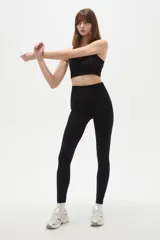 Calza deportiva de tiro alto y ajuste ceñido al cuerpo, confeccionada en tejido elástico de color bordó.