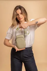 Bandolera compacta color rojo con textura de cuero, correa regulable y desmontable con diseño de rayas rojas y blancas. Cuenta con bolsillos frontales y cierre, interior forrado en tela.