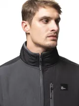 Campera de polar negro con cuello alto y cierre frontal completo. Presenta paneles de nylon en contraste en el pecho, hombros y codos, incluyendo un bolsillo vertical con cierre en el pecho y dos bolsillos laterales abiertos.