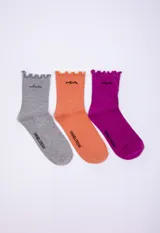 Pack de tres pares de medias de algodón de diferentes colores: gris, naranja y fucsia. Cada media tiene un bordado diferente en la parte superior y el logo de la marca en el tobillo.