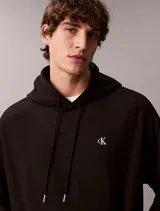 Buzo con capucha negro Calvin Klein, de felpa suave, con cordones ajustables, bolsillo tipo canguro y pequeño monograma bordado en el pecho.