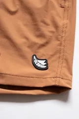 Short de baño color arcilla con bordado de enredadera en la pierna, cintura elástica con cordón ajustable, bolsillos laterales y bolsillo trasero con cierre.