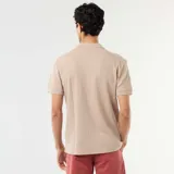 Remera polo de manga corta en color beige, confeccionada en tejido con textura de nido de abeja, con cuello camisero y escote en V.