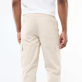 Pantalón cargo de corte regular fit en color gris claro (Gris Lune), con bolsillos laterales en las piernas y cordón ajustable en la cintura.