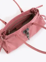 Cartera de hombro confeccionada en cuero vacuno color azul petróleo con acabado brillante. Presenta un diseño rectangular con herraje metálico tipo candado y dijes colgantes en el frente, además de correas laterales ajustables con tiras decorativas.