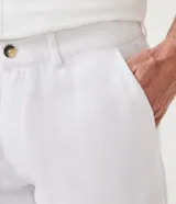 Bermuda de hombre en lino color gris claro, de corte recto, con textura discreta, bolsillos laterales y cierre frontal con botón y cremallera.