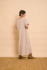 Vestido tipo túnica largo de lino color beige, de manga corta, con detalles de volados en el frente y bolsillos laterales.