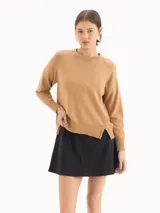 Sweater de tejido de punto color tostado, con escote redondo, mangas largas raglán y diseño holgado con aberturas laterales en el dobladillo.