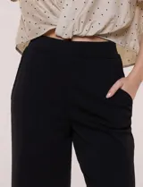 Pantalón wide leg plisado, color beige, con pretina ancha elastizada y bolsillos delanteros.