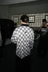 Casaca unisex de manga larga, con cuello tejido negro y estampado a cuadros en blanco crudo y negro.