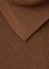 Jersey de punto fino color marrón, con diseño entallado, cuello asimétrico y detalle de botones laterales. Cuenta con manga larga.