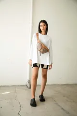 Riñonera negra de cuero vacuno con correa regulable, cierre superior con doble cremallera y bolsillo frontal con cremallera.