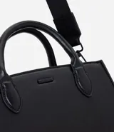 Cartera tipo satchel de tamaño mediano, confeccionada en poliuretano con acabado liso. Presenta una estructura rectangular, doble asa de mano fija y una correa larga ajustable y extraíble. Cuenta con cierre superior y herrajes metálicos.