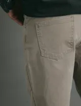 Pantalón de algodón sarga con elastano, diseño de cinco bolsillos con cierre de botón metálico y bolsillos traseros de parche.