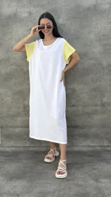 Vestido largo blanco con mangas cortas negras y corte holgado.