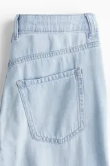 Jean de cinco bolsillos en denim rígido color celeste claro, con piernas amplias y corte holgado de talle medio.