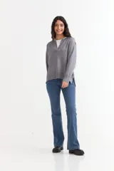 Sweater de tejido de punto color azul marino, con cuello abierto tipo polo y tajos laterales en el ruedo. Presenta mangas largas con puños acanalados y un corte holgado.