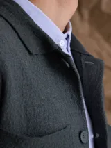 Overshirt de tejido de punto color azul marino, con cuello camisero, cierre frontal de botones y dos bolsillos frontales tipo parche.