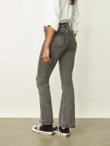 Jean de corte oxford en color negro, con tiro medio y ajuste en la cintura y caderas, ensanchándose desde la rodilla hacia el ruedo.