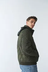 Campera de nylon azul marino para hombre con capucha, cierre frontal con cremallera, bolsillos laterales y frontales. El modelo usa talle M.