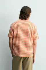 Camiseta de corte regular fit confeccionada en tejido de algodón, con diseño de rayas horizontales en color naranja y blanco, cuello redondo y manga corta.