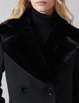 Tapado de lana Michael Kors con doble abotonadura y cuello de solapa ancha revestido en piel sintética. Presenta cierre frontal con seis botones grabados, bolsillos laterales de ojal y silueta de corte recto a la altura del muslo.