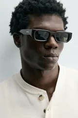 Camiseta relaxed fit color crema, con cuello redondo tipo panadero y cierre frontal de tres botones. Manga larga y acabados en rib.