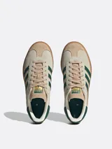 Championes Adidas Gazelle Bold para mujer, color beige con detalles en verde oscuro y suela de goma marrón de triple plataforma.