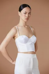 Top tipo corset de color blanco, con escote corazón, estructura con varillas y breteles finos ajustables.