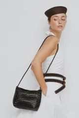Cartera tipo morral y bandolera de cuero vacuno marrón, completamente trenzada a mano con diseño estructurado y correa larga trenzada.